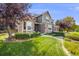 Beautifully landscaped front yard with lush green lawn, mature trees, and a charming pathway to the entrance at 1274 Meyerwood Ln, Highlands Ranch, CO 80129