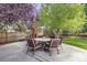 Patio with a stone table, six chairs, and lush greenery at 1274 Meyerwood Ln, Highlands Ranch, CO 80129