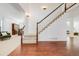 View of the staircase with carpet, white railing, hardwood floors, and a glimpse into the living spaces at 1274 Meyerwood Ln, Highlands Ranch, CO 80129