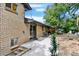 View of the patio, sliding glass door, brick exterior, and rock-covered landscaping at 400 S Hoyt St, Lakewood, CO 80226