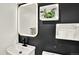 Modern bathroom with sleek black and white design, unique mirror, and decorative shelving at 400 S Hoyt St, Lakewood, CO 80226