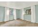 Bright bedroom with neutral carpet, two windows with curtains, and light-blue walls at 400 S Hoyt St, Lakewood, CO 80226