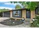 Charming front exterior of a brick home with a manicured yard, dark door, and a two car garage at 400 S Hoyt St, Lakewood, CO 80226