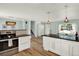 Open kitchen with stainless steel oven, white cabinets, and eat-in bar with modern lighting at 400 S Hoyt St, Lakewood, CO 80226