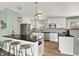 Modern kitchen features white cabinetry, stainless steel appliances, and a breakfast bar with seating at 400 S Hoyt St, Lakewood, CO 80226
