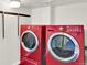 Modern laundry room showcasing red front-load washer and dryer for efficient and stylish home convenience at 400 S Hoyt St, Lakewood, CO 80226