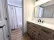 Well-lit bathroom with a wood vanity, black hardware, and a shower-tub combo at 7101 W Yale Ave # 1206, Denver, CO 80227