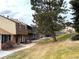 Brick townhome with walkway, landscaping, and a large tree in front at 7101 W Yale Ave # 1206, Denver, CO 80227