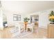 Bright dining room with round table, white chairs, and kitchen view at 14129 W Center Dr, Lakewood, CO 80228