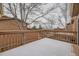 Back deck with wood railings is covered in snow; trees fill the skyline on an overcast day at 45 Wright Ct, Lakewood, CO 80228