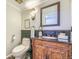 Stylish bathroom with a carved wood vanity, black countertop, and copper colored vessel sink at 45 Wright Ct, Lakewood, CO 80228