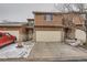 Exterior shot of a tan two-story townhome with a two-car garage on a snow-covered driveway at 45 Wright Ct, Lakewood, CO 80228