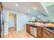 Kitchen with stainless steel appliances, wooden cabinets, breakfast bar, and bright lighting at 45 Wright Ct, Lakewood, CO 80228