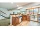 Open-concept kitchen with wooden cabinets, breakfast bar, and view of the dining and living areas at 45 Wright Ct, Lakewood, CO 80228