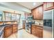 Modern kitchen with wooden cabinets, stainless steel appliances, and a view into the dining area at 45 Wright Ct, Lakewood, CO 80228