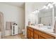 Bright bathroom featuring double sinks, wood cabinets, and neutral decor at 10818 Cimarron St # 1102, Firestone, CO 80504
