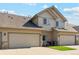 Townhome featuring attached garages, neutral siding, a well-maintained lawn, and a blue sky at 10818 Cimarron St # 1102, Firestone, CO 80504