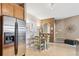 Cozy eat-in kitchen area with stainless steel refrigerator, wood cabinets, and ample sunlight at 10818 Cimarron St # 1102, Firestone, CO 80504