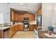 Well-lit kitchen with stainless steel appliances, wood cabinets, and breakfast bar seating at 10818 Cimarron St # 1102, Firestone, CO 80504