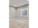 This bedroom has a window letting in natural light, carpet, and neutral paint at 1960 Wabash St, Denver, CO 80220