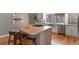 Kitchen island with seating, stainless steel sink, wooden countertop, and modern fixtures at 1960 Wabash St, Denver, CO 80220