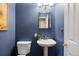 Cozy half bathroom with a pedestal sink, square mirror, and a blue painted wall at 2 S Monroe St, Denver, CO 80209