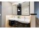Bathroom featuring double sinks with dark wood cabinets and a large mirror at 2 S Monroe St, Denver, CO 80209