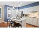 Modern kitchen with white cabinets, stainless steel appliances, island with seating, and pendant lighting at 2 S Monroe St, Denver, CO 80209