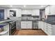 Modern kitchen with white cabinetry, stainless steel appliances, and grey backsplash at 1165 N Pennsylvania St # G2, Denver, CO 80203