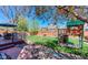 Inviting backyard featuring a playset, deck area, and green lawn, perfect for outdoor activities at 14533 W 69Th Pl, Arvada, CO 80004