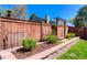 Landscaped backyard with stone retaining wall, mulch beds, and wood fence at 14533 W 69Th Pl, Arvada, CO 80004