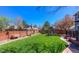Large, well-manicured backyard with lush green grass, a play structure, and privacy fencing at 14533 W 69Th Pl, Arvada, CO 80004