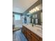 Bright bathroom with double sink vanity, large mirror and modern fixtures over a tub-shower at 14533 W 69Th Pl, Arvada, CO 80004
