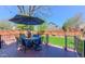 Outdoor deck area with patio furniture, umbrella, and view of the landscaped backyard and privacy fence at 14533 W 69Th Pl, Arvada, CO 80004