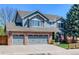 Charming two-story home with a brick and siding exterior and a well-manicured front yard, plus a three car garage at 14533 W 69Th Pl, Arvada, CO 80004