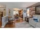 Inviting living room featuring hardwood floors, decorative wood wall, a rocking chair and seamless flow into the dining area at 14533 W 69Th Pl, Arvada, CO 80004