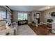 Inviting living room with hardwood floors, neutral paint, plantation shutters, and a comfortable sofa at 14533 W 69Th Pl, Arvada, CO 80004