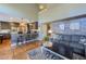 Open concept living space with modern kitchen bar, hardwood floors, and comfortable gray sofa at 14533 W 69Th Pl, Arvada, CO 80004