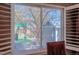 This window view showcases a charming backyard featuring a custom playhouse and play structure at 14533 W 69Th Pl, Arvada, CO 80004