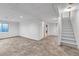 Spacious finished basement with tile flooring, neutral walls, and access to stairs at 1606 Iris St, Broomfield, CO 80020