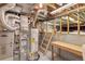 Unfinished basement utility area with water heater, HVAC, exposed ducts and beams, and a wooden ladder to lofted storage at 1606 Iris St, Broomfield, CO 80020