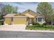 Charming yellow home featuring an attached garage and beautifully landscaped front yard at 1606 Iris St, Broomfield, CO 80020