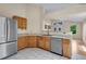 Bright kitchen features stainless steel appliances, wooden cabinets and stylish backsplash at 1606 Iris St, Broomfield, CO 80020