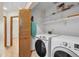Convenient laundry room featuring a modern washer and dryer set, ample shelving, and folding door at 1606 Iris St, Broomfield, CO 80020