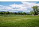 Scenic view of neighborhood with a sprawling green field and a backdrop of majestic snow-capped mountains at 1606 Iris St, Broomfield, CO 80020