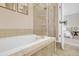 Bathroom featuring a soaking tub with tile surround and view of the main bedroom at 3662 Castle Peak Ave, Superior, CO 80027