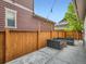 This backyard features a concrete patio, a wooden fence, an outdoor sofa set, and string lights at 10479 E 25Th Dr, Aurora, CO 80010