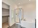 Bright bathroom featuring a glass-enclosed shower, soaking tub, and walk-in closet at 10479 E 25Th Dr, Aurora, CO 80010