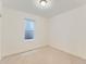 A simple bedroom with white walls, carpet, and a small window at 10479 E 25Th Dr, Aurora, CO 80010