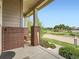Welcoming front porch featuring brick pillars, a swing, and a view of a park across the street at 10479 E 25Th Dr, Aurora, CO 80010
